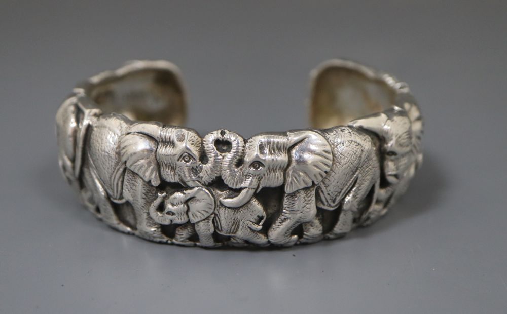 A modern white metal bangle modelled as a heard of elephants by Patrick Mavros,